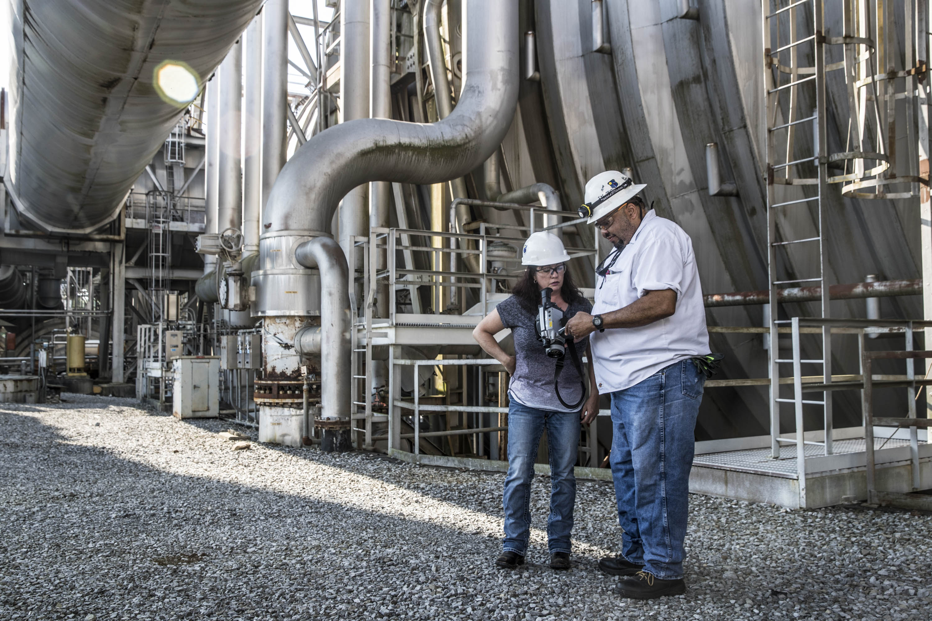 Industrial operations team reviewing equipment inside a large process plant