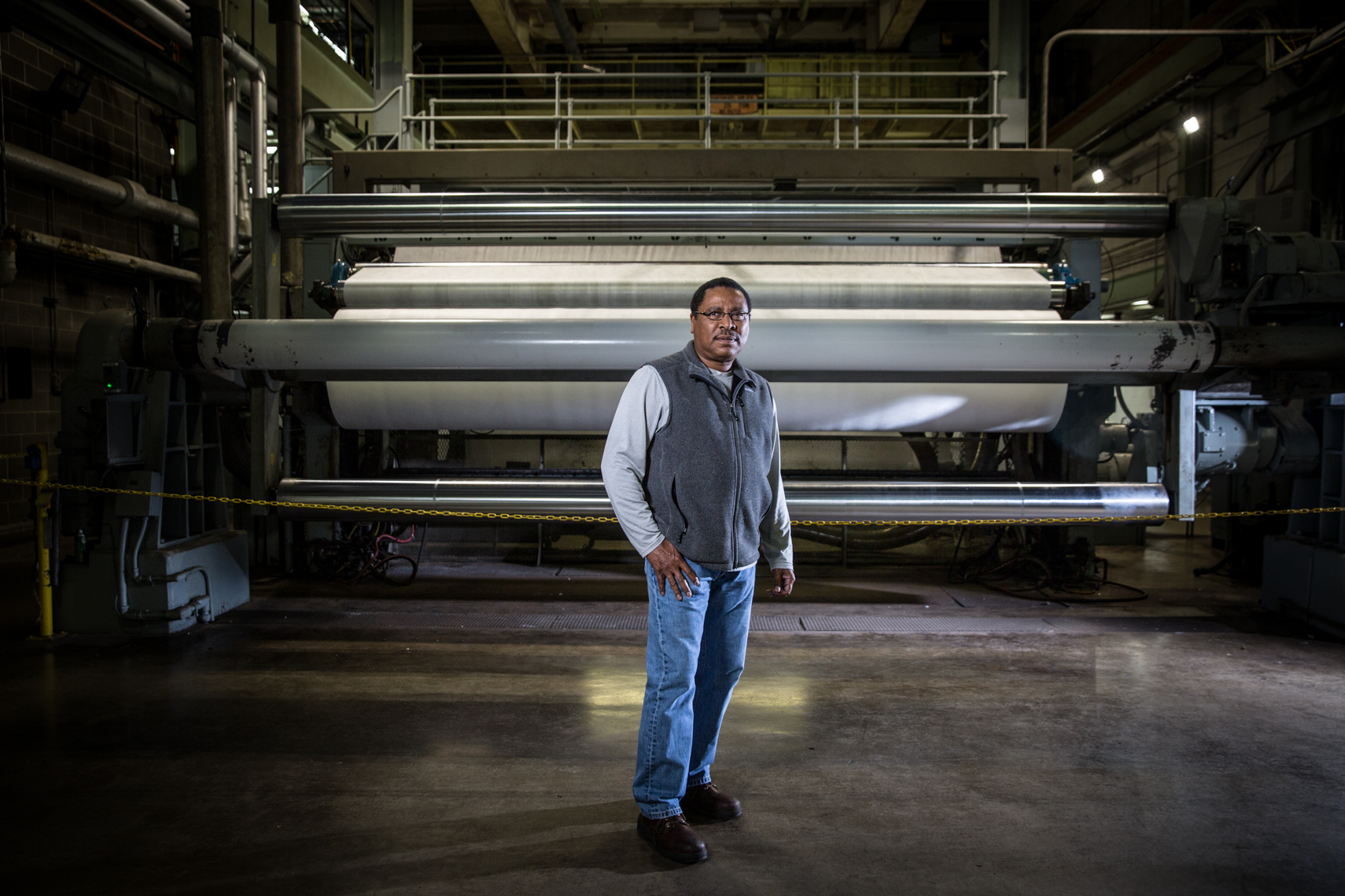 Paper manufacturing worker portrait in front of production machinery