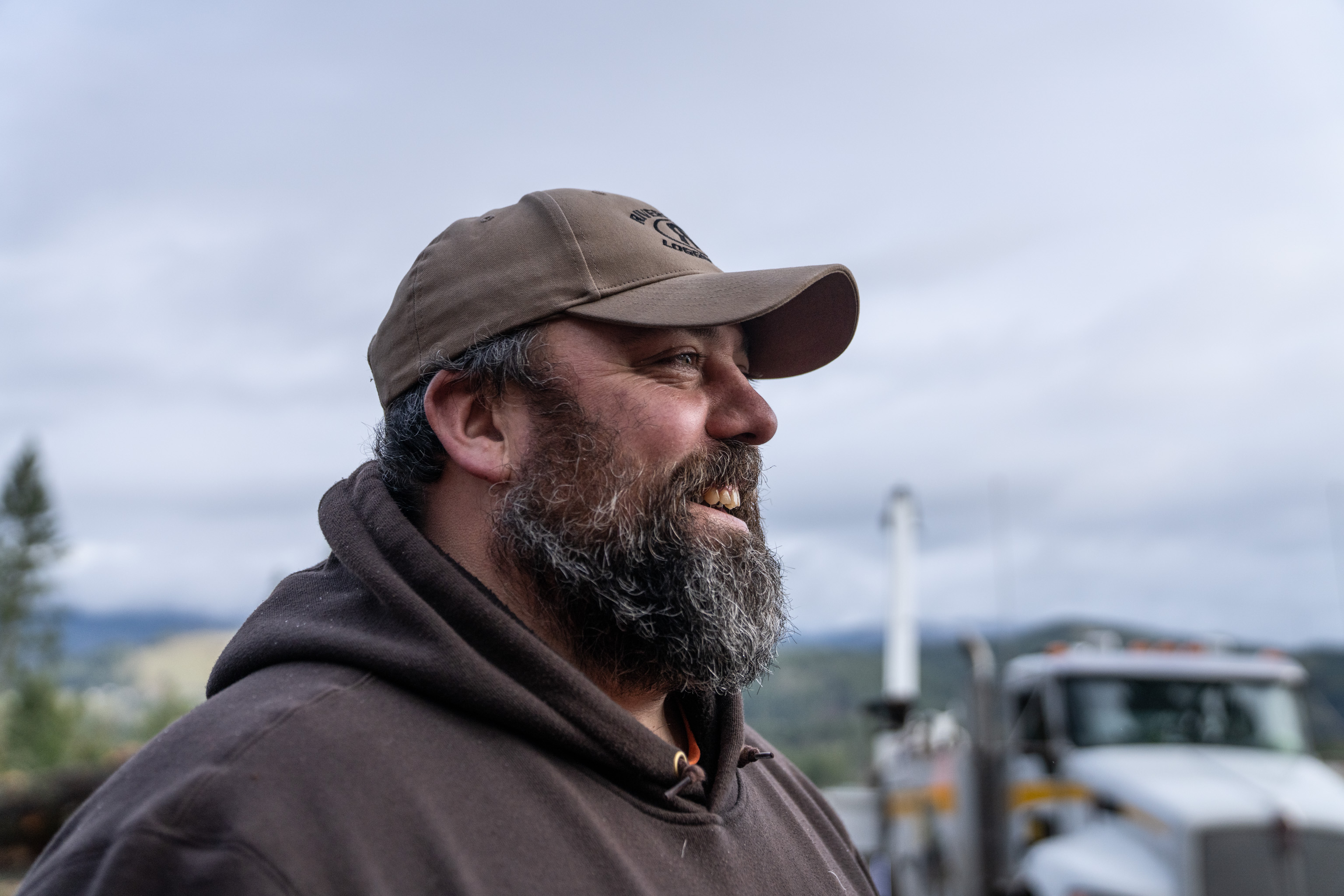 Logging worker portrait beside heavy equipment in a timber operation