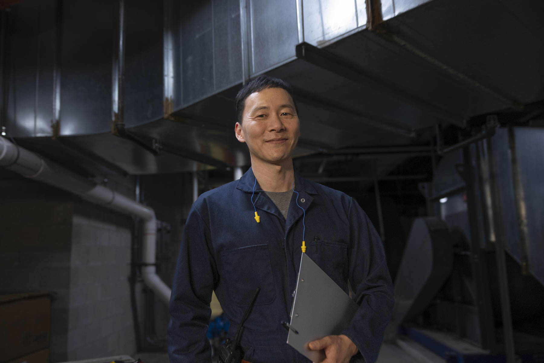Industrial maintenance worker portrait inside an active manufacturing facility