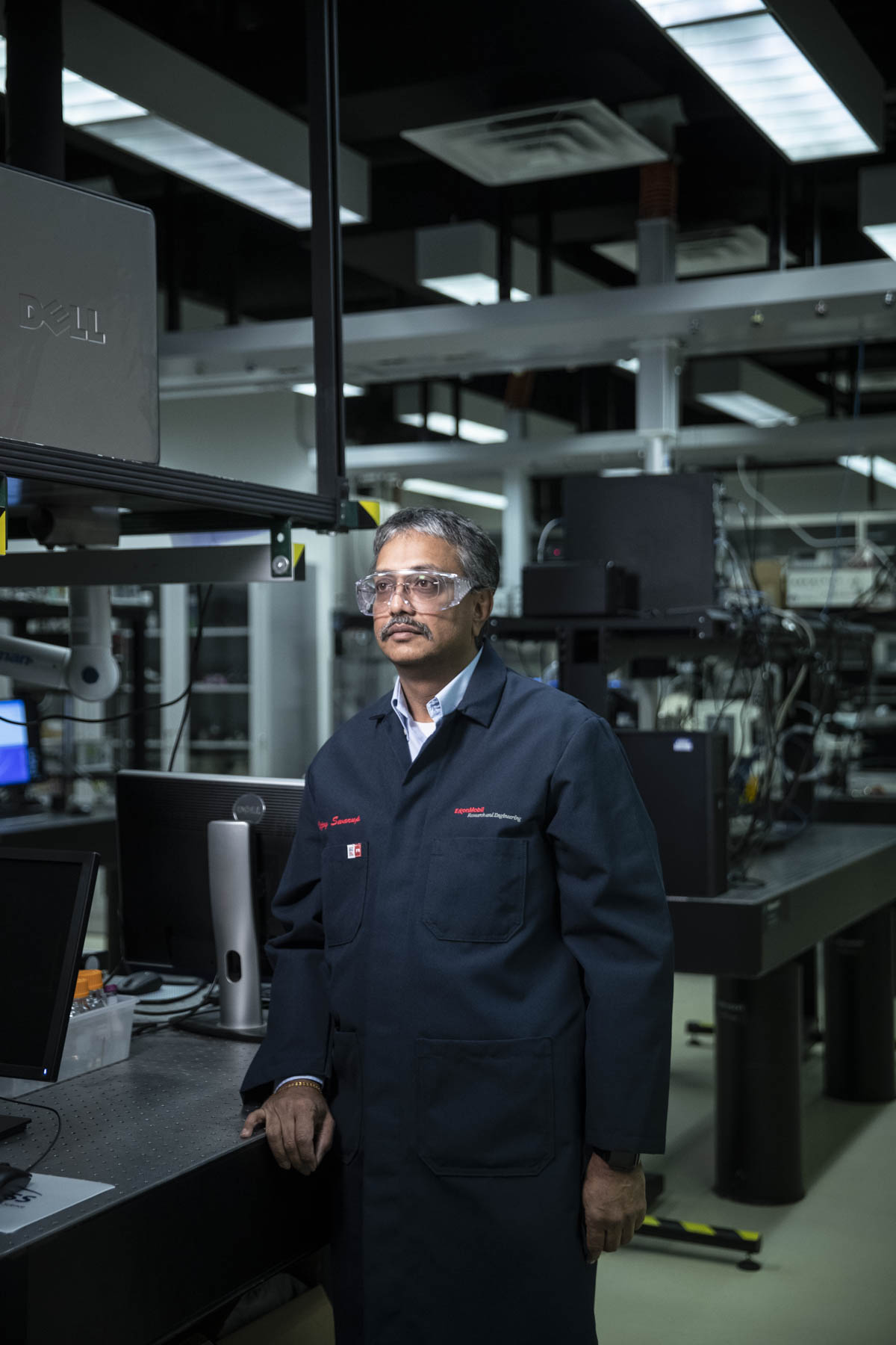 Manufacturing laboratory technician wearing safety glasses beside testing equipment