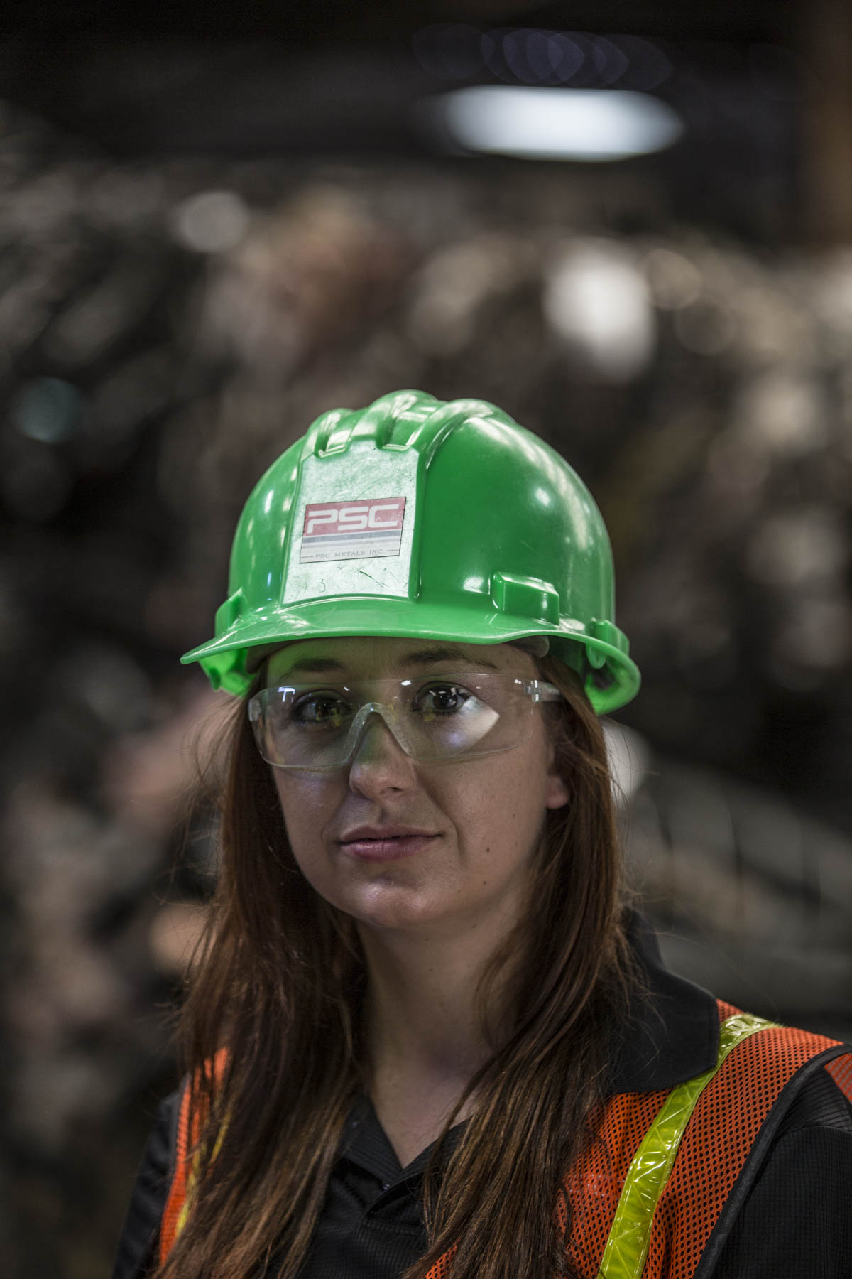 Metals recycling worker wearing a hard hat, safety glasses, and high-visibility gear
