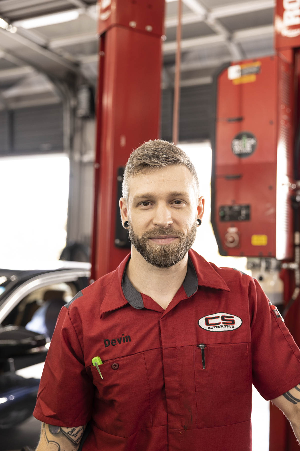 Automotive technician portrait inside a vehicle service facility