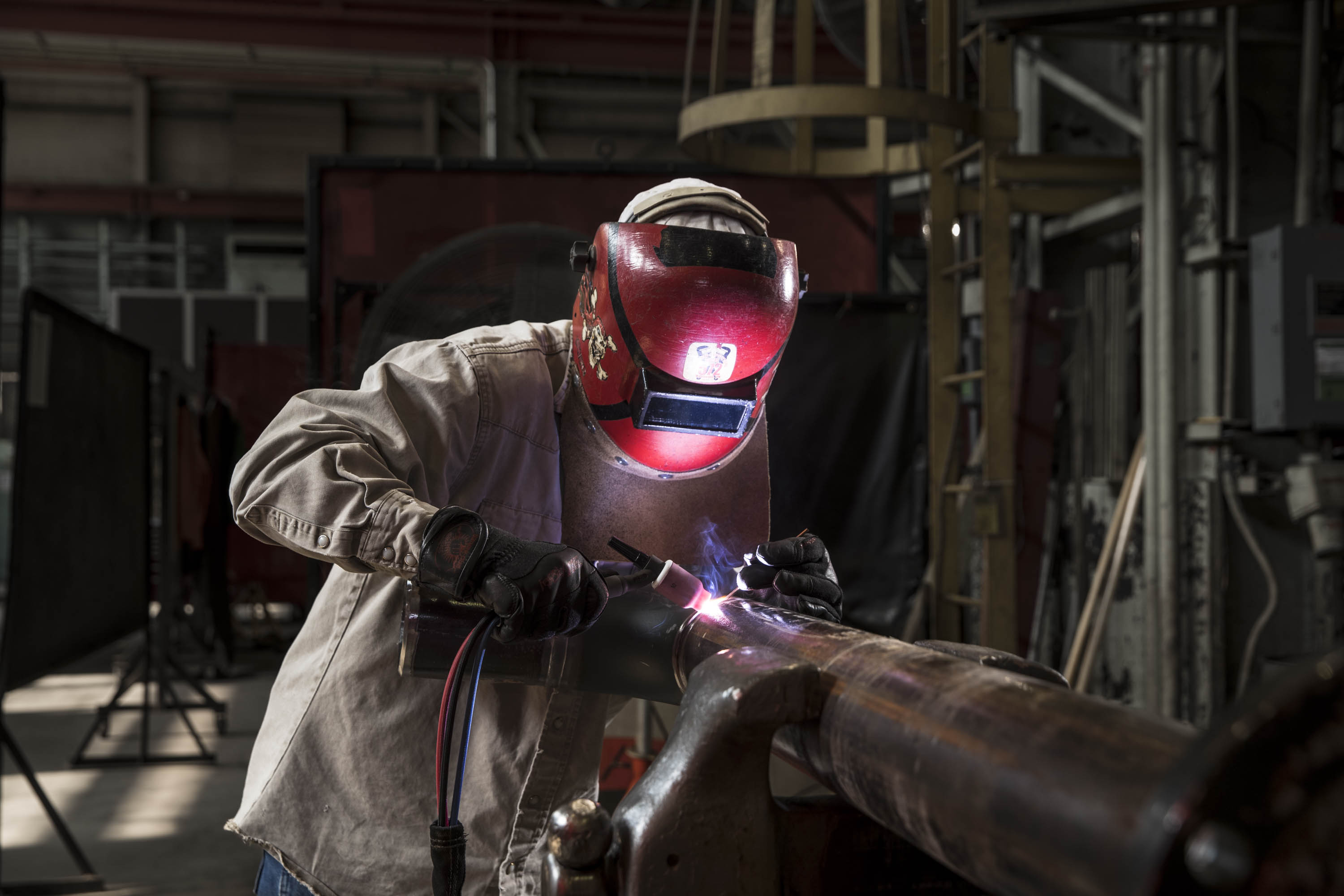 Welder performing precision fabrication inside a government industrial facility