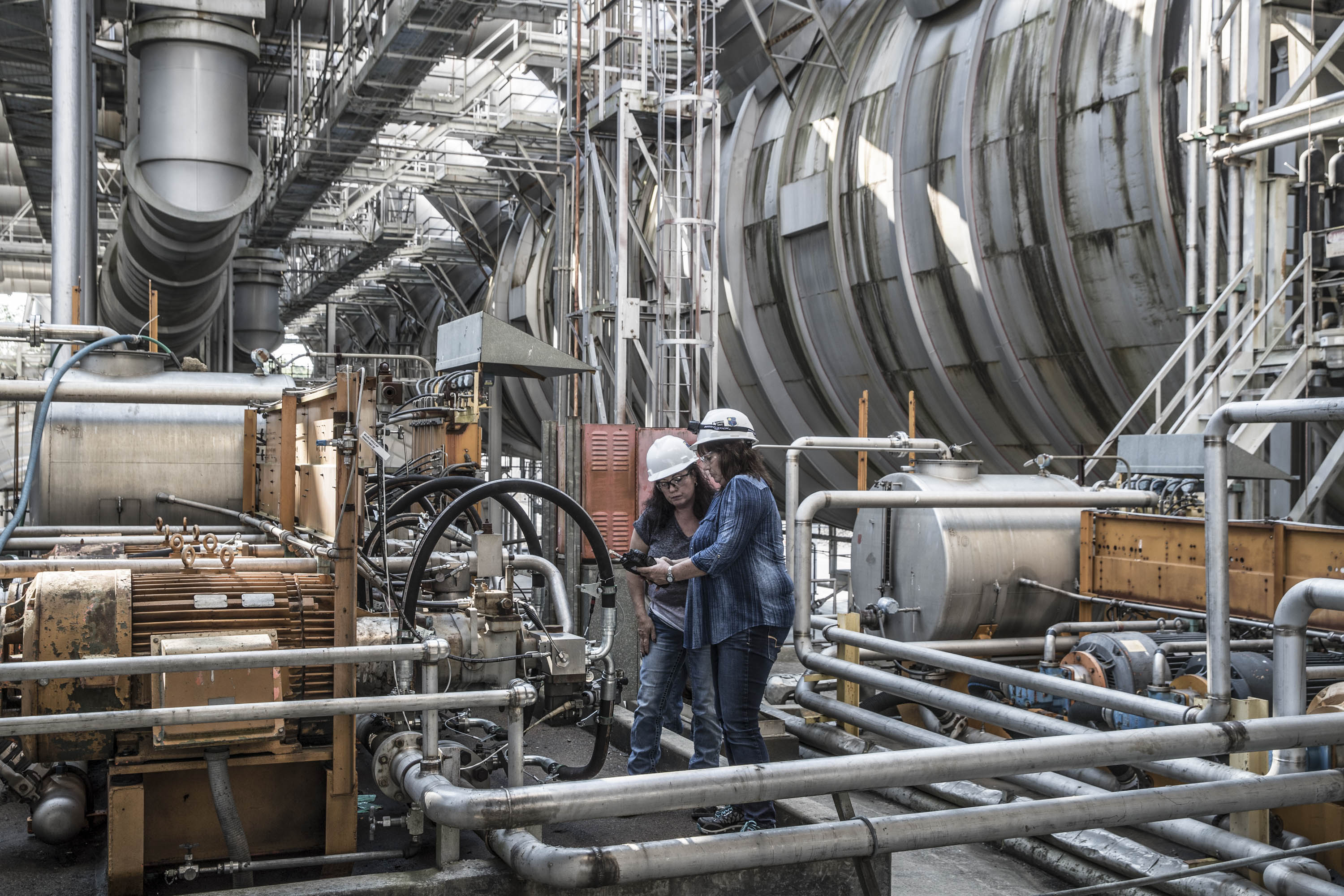 Technical team reviewing systems within a complex industrial facility