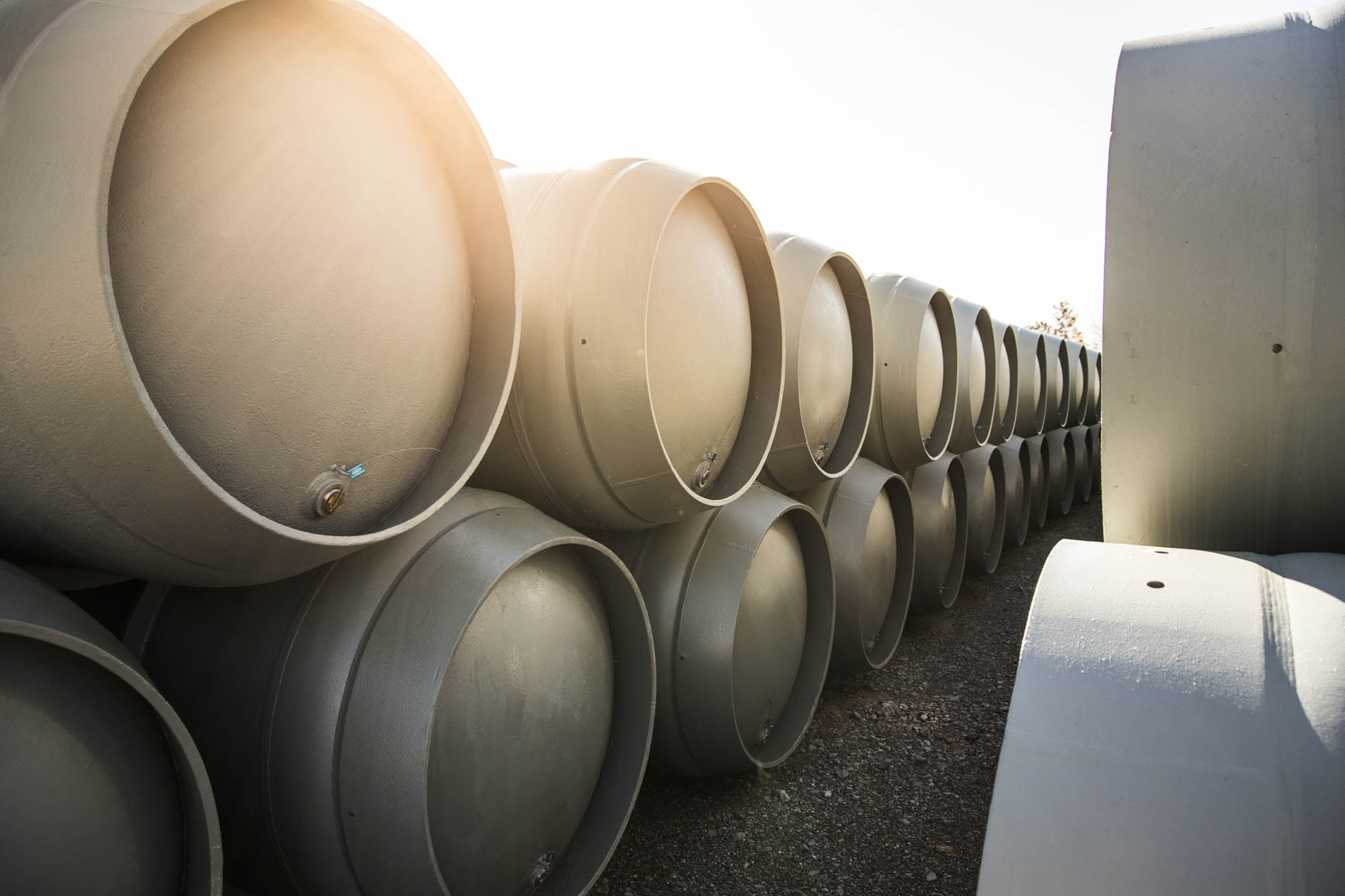 Row of nuclear fuel transport casks staged outdoors at golden hour