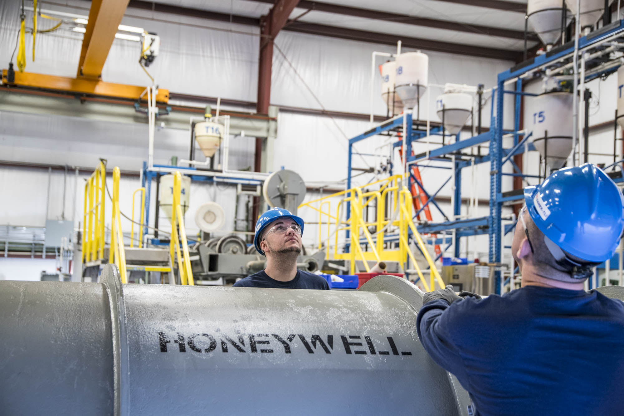 Technicians inspecting a marked cask inside the fabrication facility