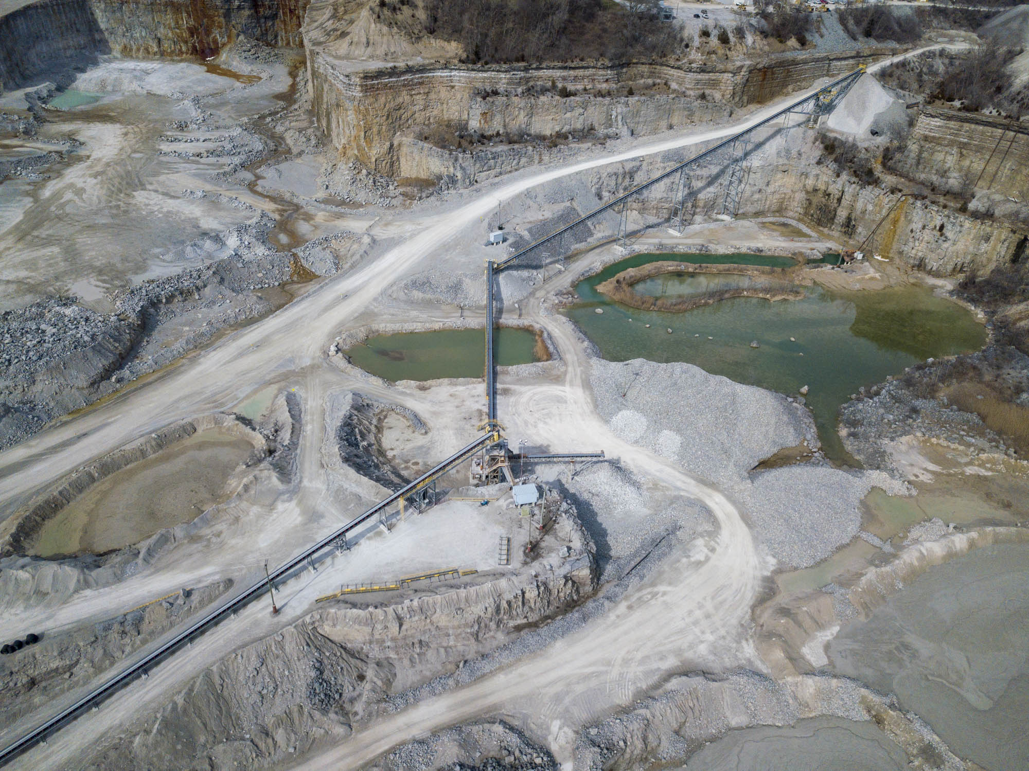 Aerial view of a conveyor incline spanning the quarry pit