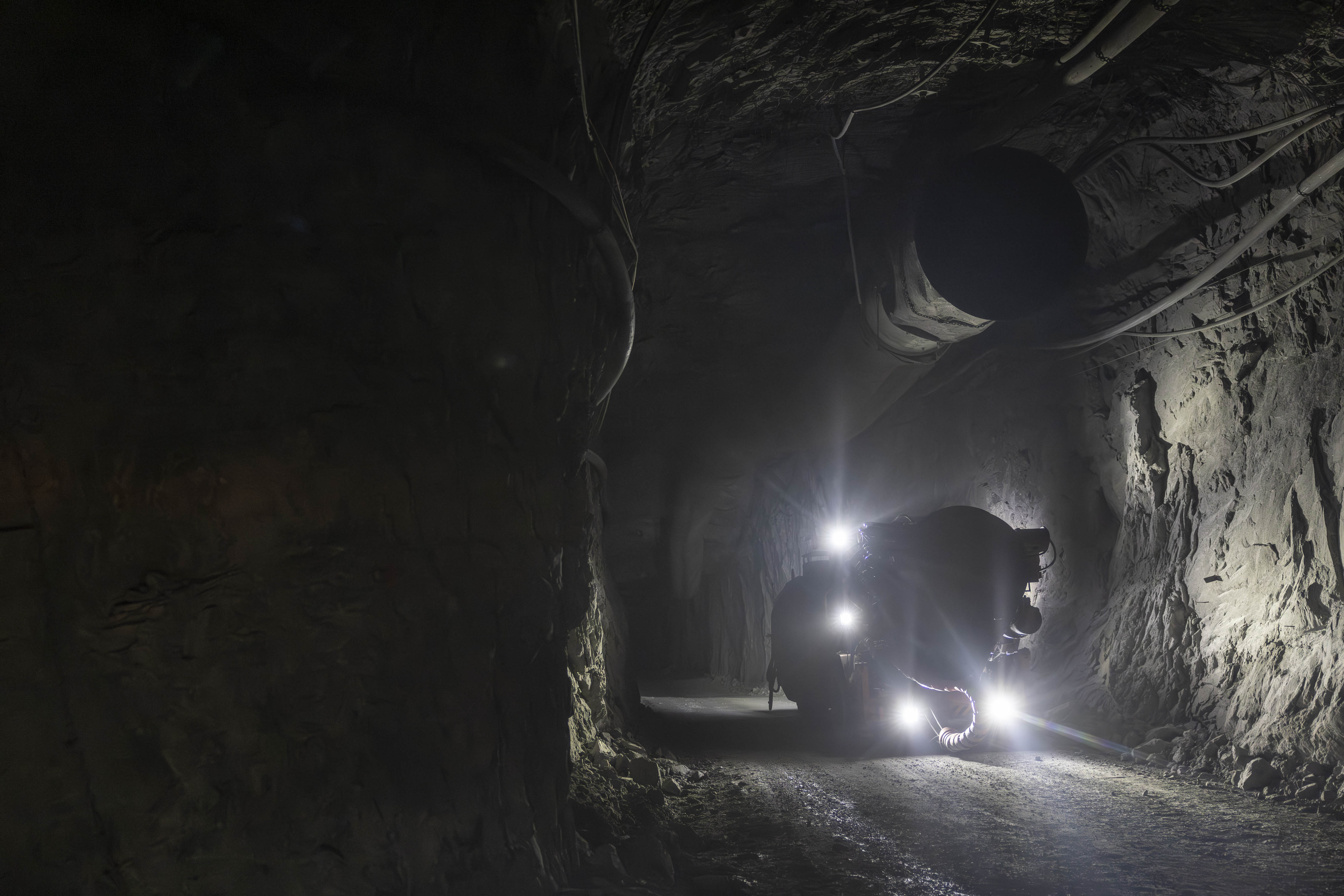 Underground drill rig advancing through a hard-rock mine tunnel