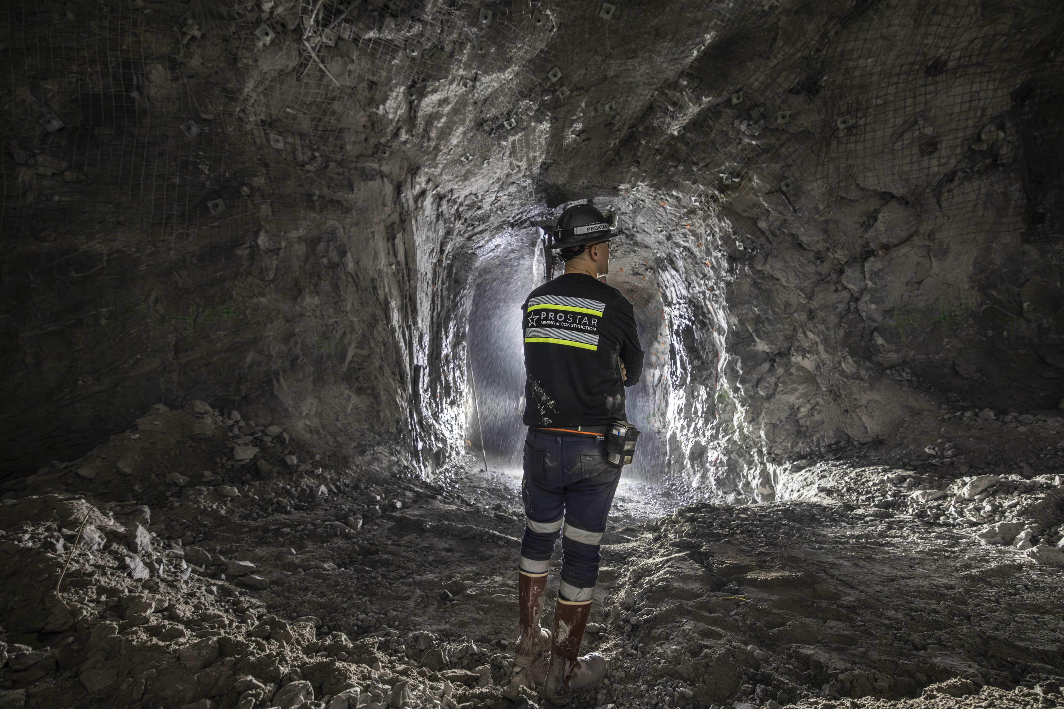 Underground miner inspecting a newly developed opening with rock support installed