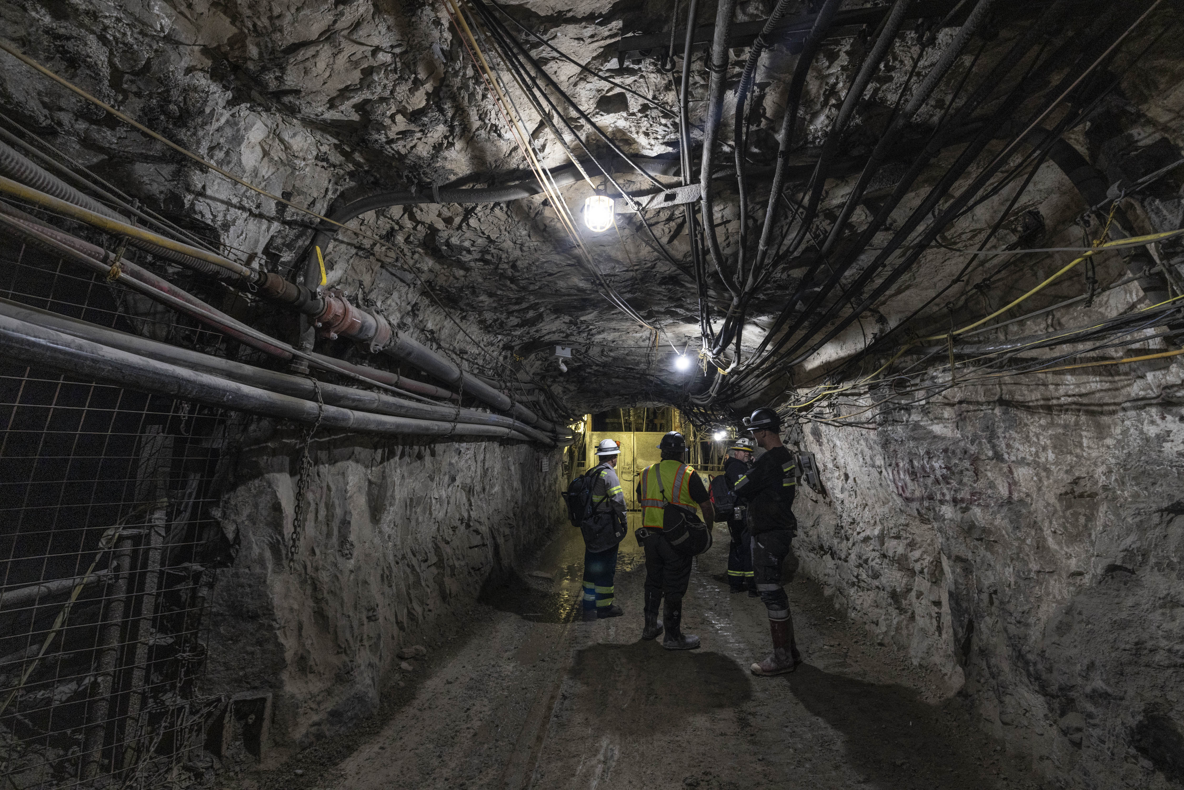 Underground mining team coordinating beneath active mine utilities and services