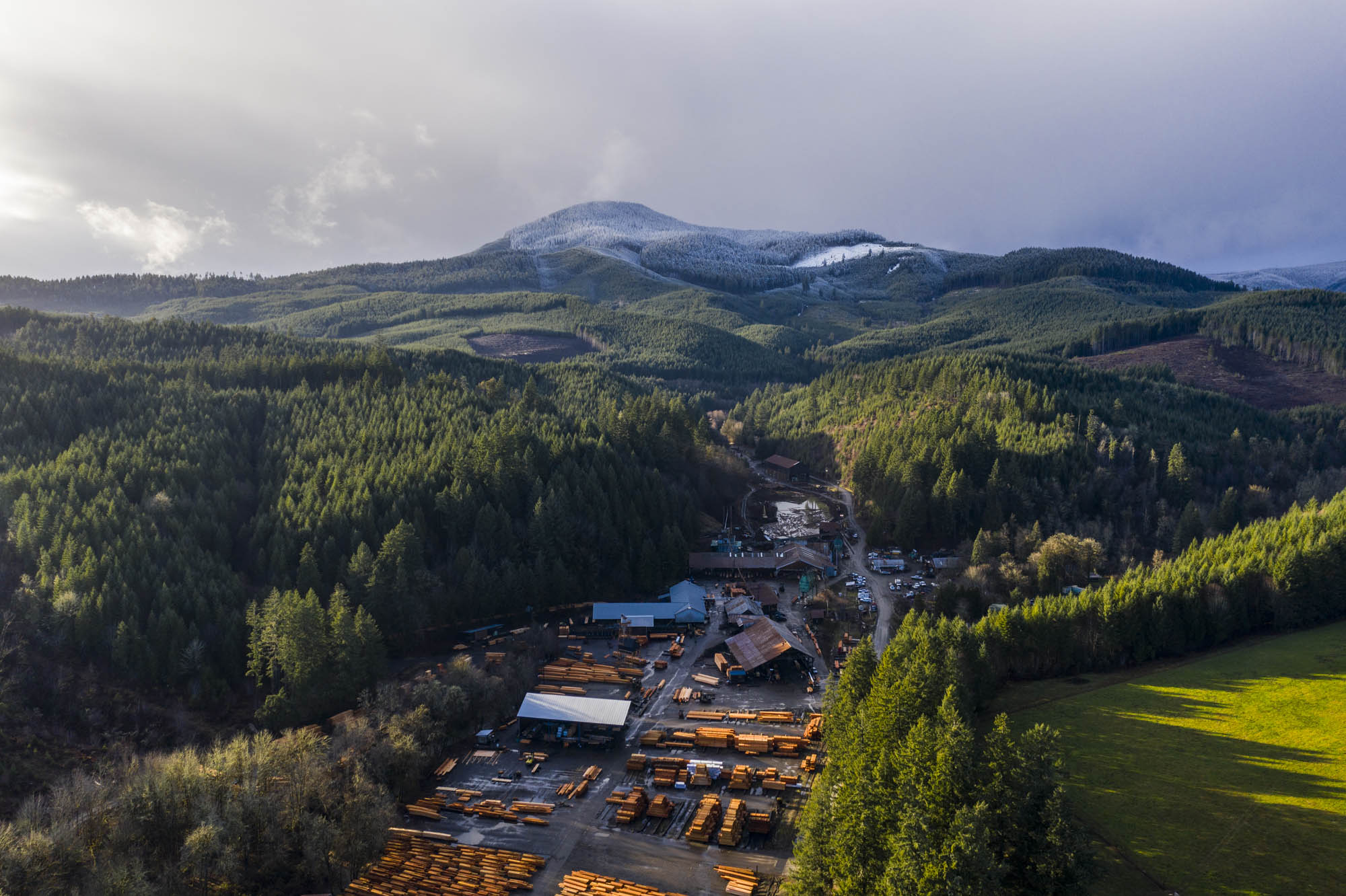 Aerial view of a sawmill operation set among forested mountains