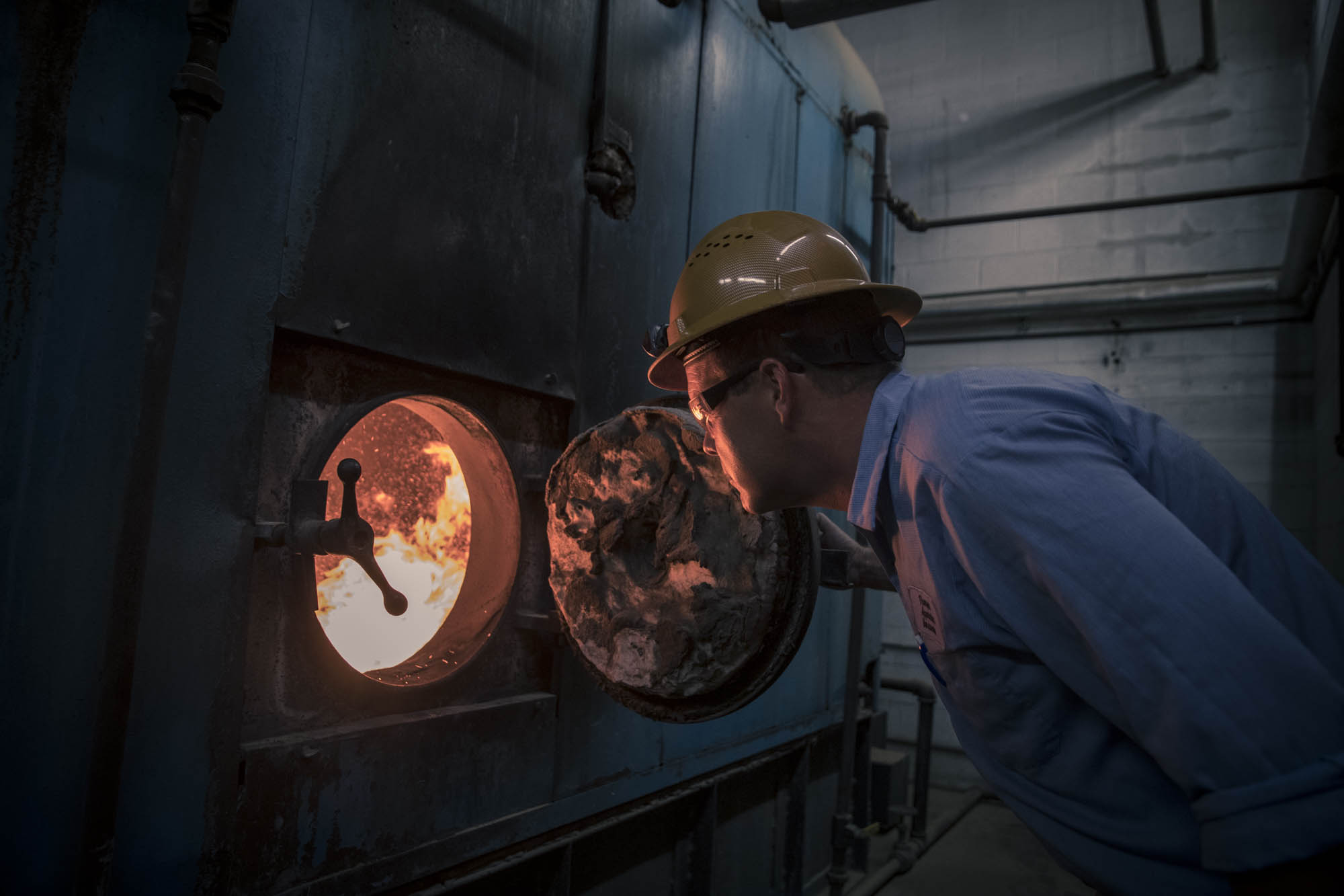 Technician inspecting an open boiler firebox