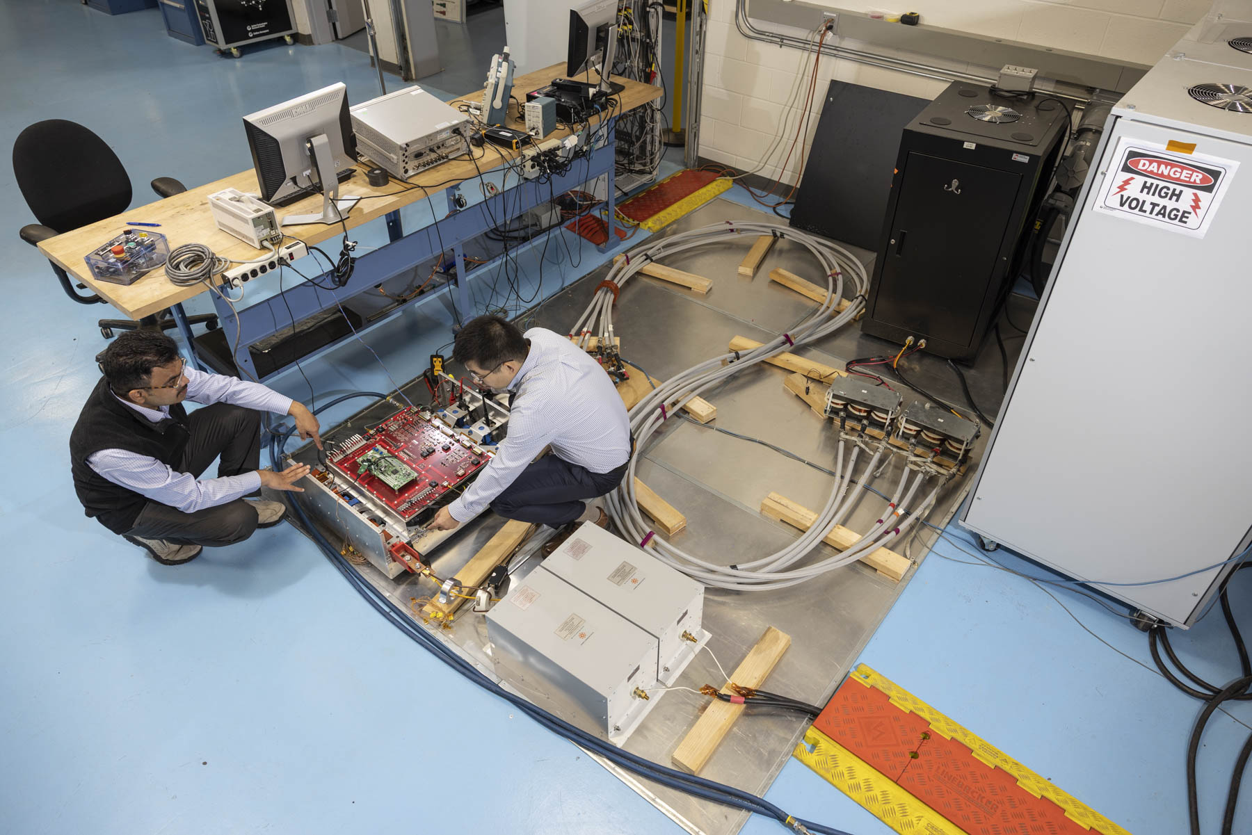 Overhead view of engineers assembling aerospace propulsion test equipment